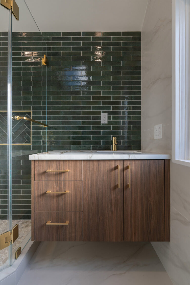 Palo Alto bathroom remodel vanity elevation with a walnut floating cabinet, brushed brass bar pulls, a Calacatta-look countertop with gold veins, a slim brass faucet, and a full wall of glossy green subway tile.