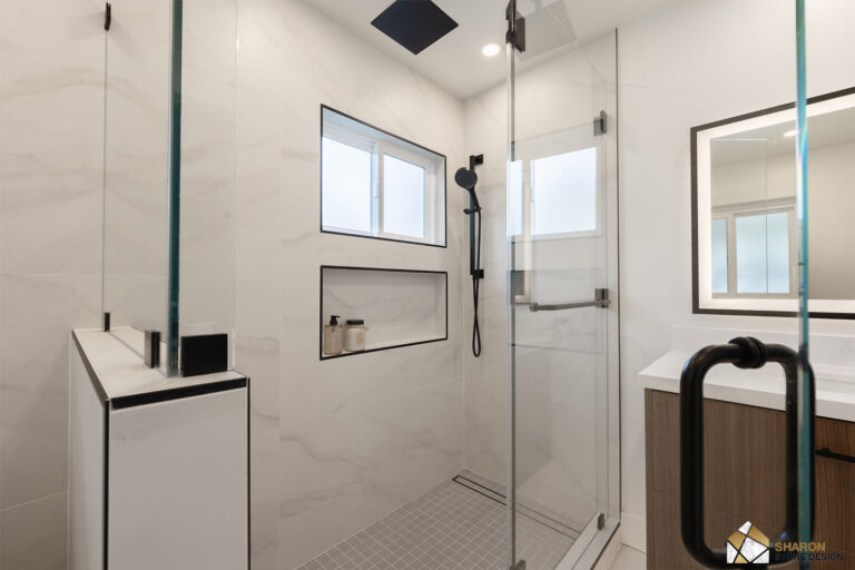Redwood City home remodel shower interior with a ceiling rain head, a handheld on a black slide bar, a long shampoo niche trimmed in black Schluter profile, and a gray mosaic floor draining to a linear channel.