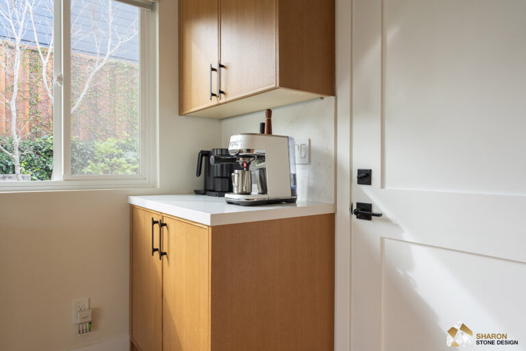 Redwood City home remodel coffee station in white oak cabinetry with black bar pulls, a quartz counter and upstand, beside a window.
