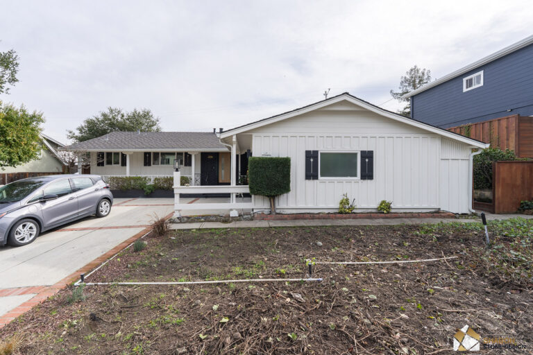 Before remodel: the Redwood City house from the street, a white board-and-batten ranch with black shutters and a covered porch.