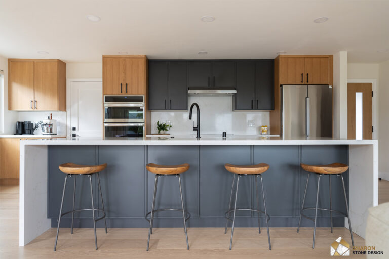 Redwood City home remodel kitchen photographed square on, with charcoal upper cabinets flanked by white oak towers, a stainless hood over the cooktop, and a quartz slab backsplash.