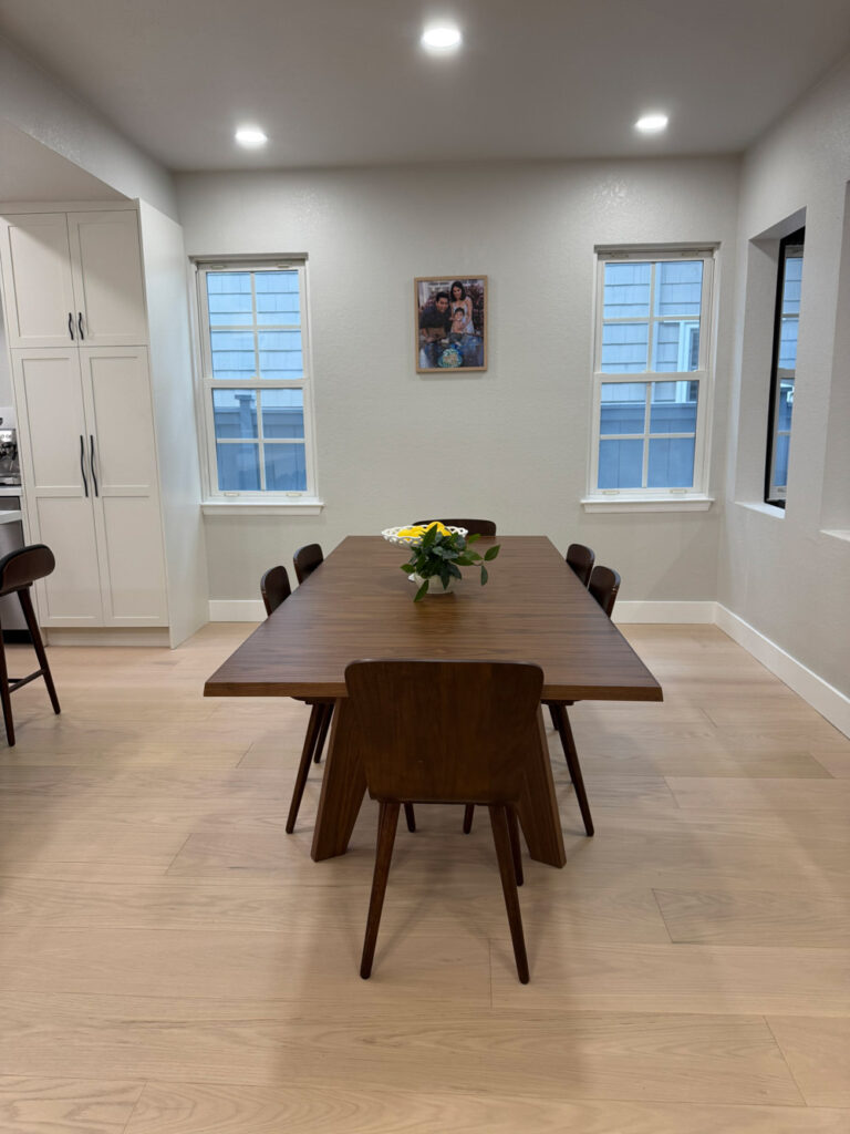 Redwood City home remodel dining room square on, centered between two windows with a tall white pantry cabinet at left.