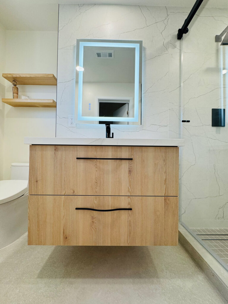 San Jose bathroom remodel vanity elevation in pale oak with black bar pulls beneath a quartz top, flanked by oak floating shelves and the black-railed shower enclosure.