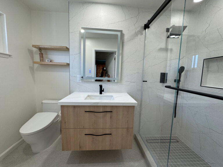 San Jose bathroom remodel full view showing the oak vanity, oak floating shelves, bidet toilet and glass shower.
